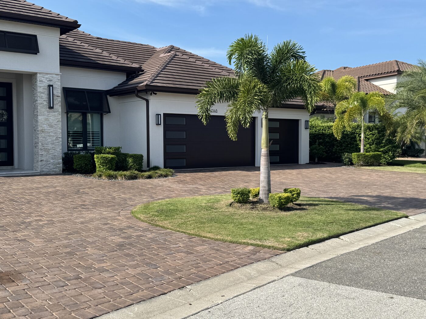 Manicured turf, mulch beds, and paver driveway on a Lakeland estate property